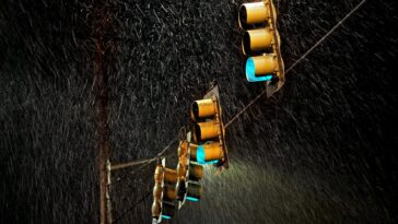 four traffic lights under the rain