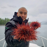 Douglas Neasloss holding two sea urchins.