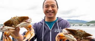 Restaurant owner and chef Dai Fukasaku holding two Dungeness Crabs.