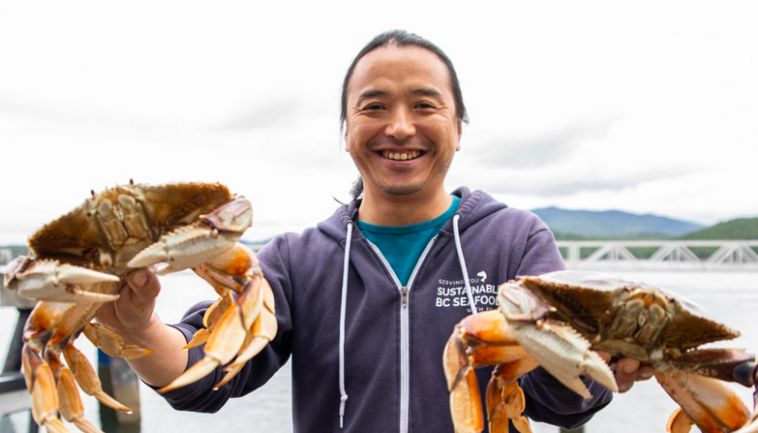 Restaurant owner and chef Dai Fukasaku holding two Dungeness Crabs.