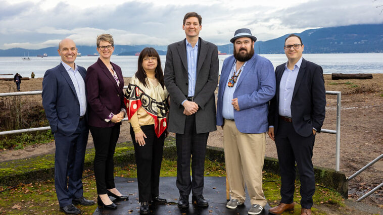 Nathan Cullen, Minister of Water, Land and Resource Stewardship; Jennifer Rice, Parliamentary Secretary for Rural Health; K̓áwáziɫ Marilyn Slett, Chief Councillor of the Heiltsuk Nation and President of Coastal First Nations; Premier David Eby; Dallas Smith, President of Nanwakolas Council; and Eddy Adra, CEO of Coast Funds at the funding announcement in Vancouver.