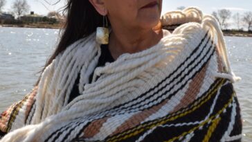 A woman wearing a Coast Salish blanket.