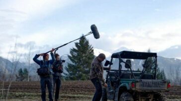 A man holding a mic boom over a filming scene from the documentary, "Tea Creek".