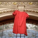 A red dress hung over an arch at a government building
