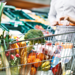 close up image of a grocery cart filled with fresh vegetables