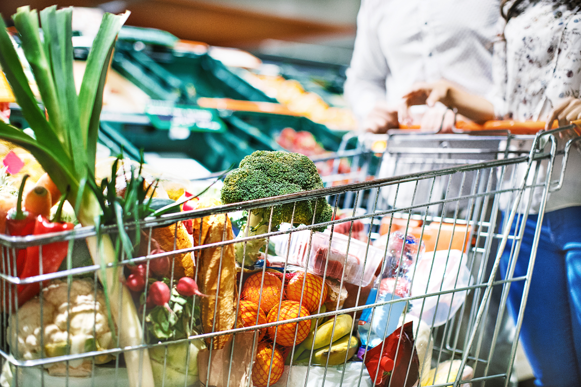 close up image of a grocery cart filled with fresh vegetables