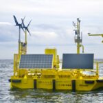 A yellow aluminum buoy with wind and solar measuring instruments floats off the coast of Haida Gwaii