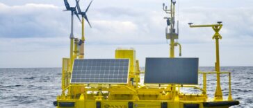 A yellow aluminum buoy with wind and solar measuring instruments floats off the coast of Haida Gwaii