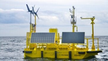 A yellow aluminum buoy with wind and solar measuring instruments floats off the coast of Haida Gwaii