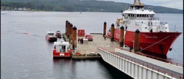 A red Canadian Coast Guard vessel reloading at a dock