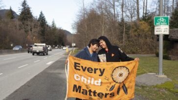 Kimberly (left) and Jordan Joseph on Highway 99, Sḵwx̱wú7mesh (Squamish). The couple planned a walk from “Prince Rupert” to “Victoria” raising awareness for indigenous children in foster care